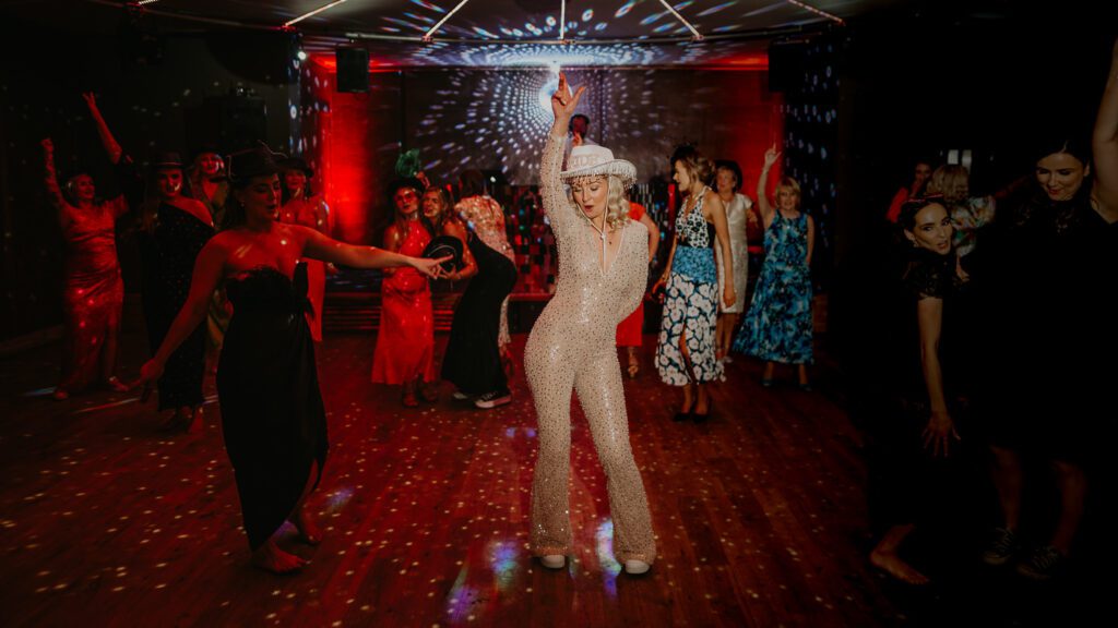 Bride surprises the wedding guests with an outfit change into a sequin jumpsuit.