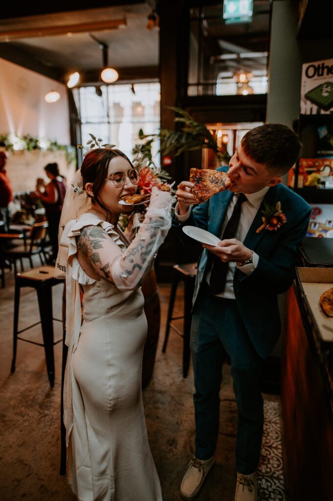 Bride and Groom eat pizza at their alternative wedding in Worcester.