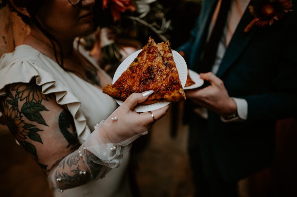 Bride holds a pizza at her alternative wedding in Worcester.