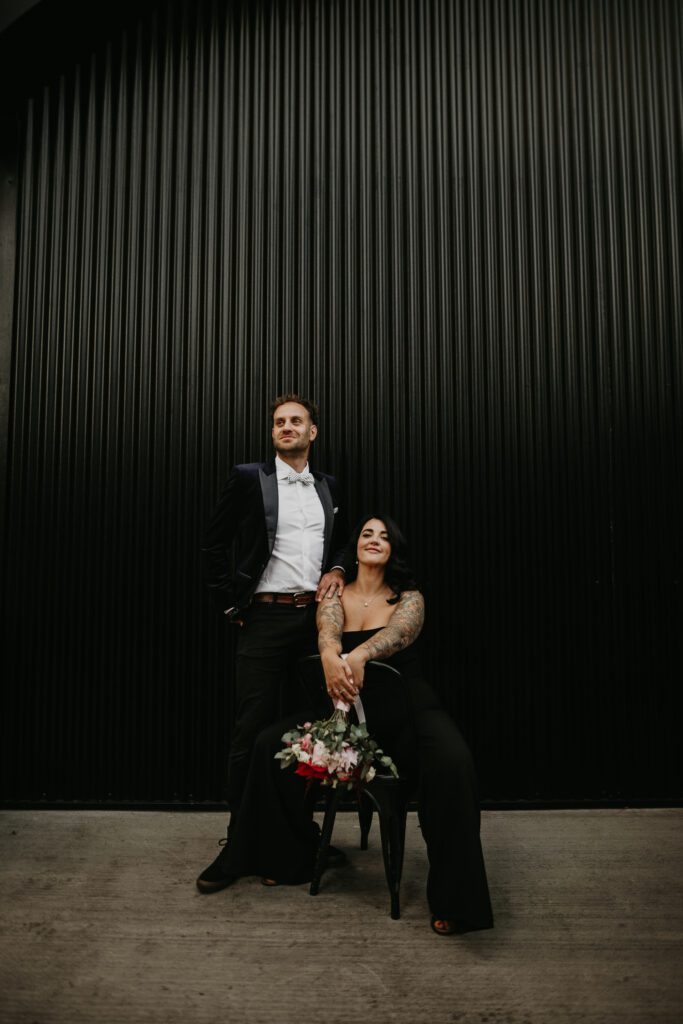 Bride and Groom outside the Shack Revolution in there evening outfit. The bride wearing a black jumpsuit.