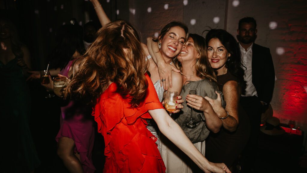 A bride dances with her bridesmaids at her wedding reception at 100 Barrington.