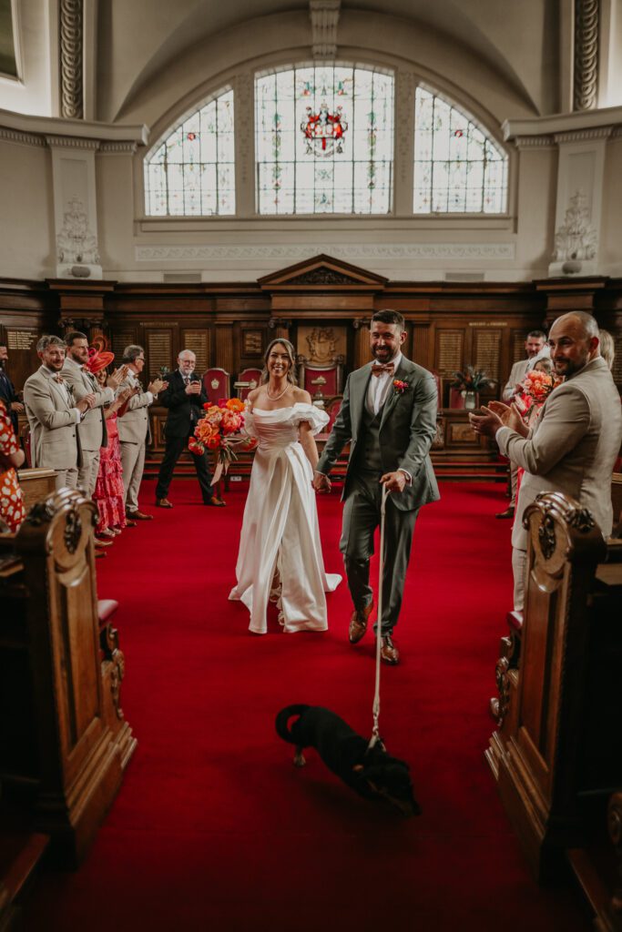 Bride and Groom exit their ceremony with their dog at Islington Town Hall.