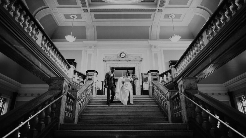 Bride and Groom walk down the stairs at Islington Town Hall.