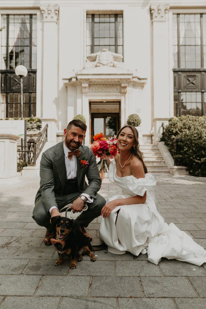 Bride and Groom outside Islington Town Hall with their dog.