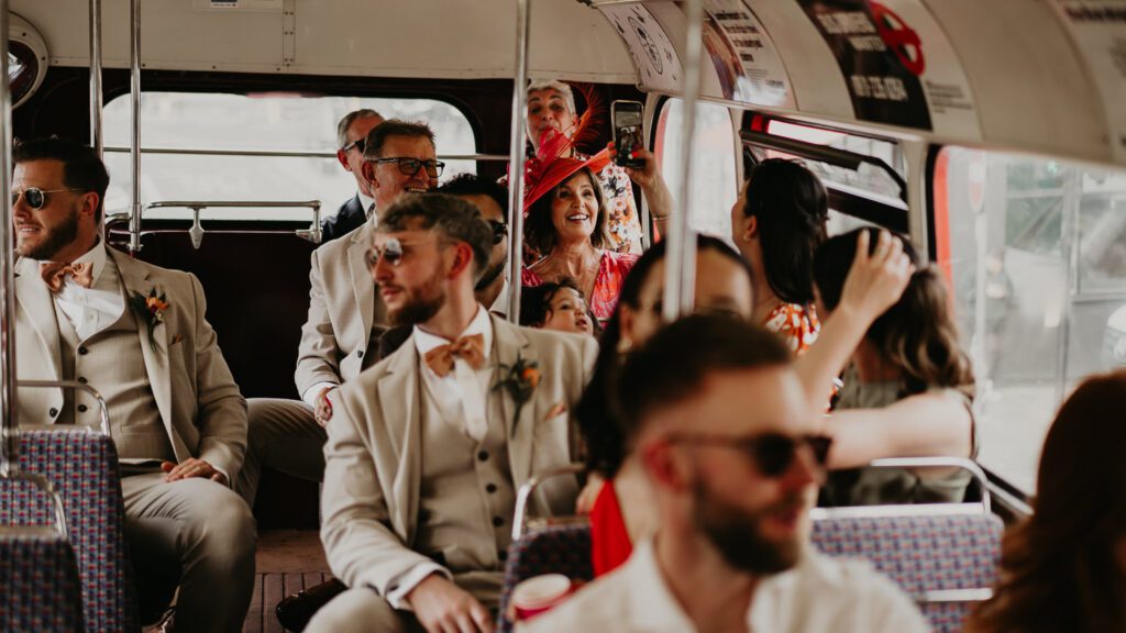 Wedding guests on a red route master London bus.