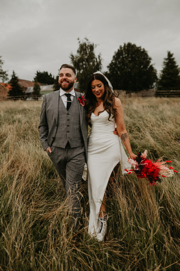 Tattooed bride and groom have couples photos in the long grass fields on their wedding day in Newcastle.