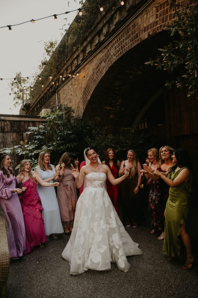 A Bride and Bridesmaids dancing at an outside wedding in London.