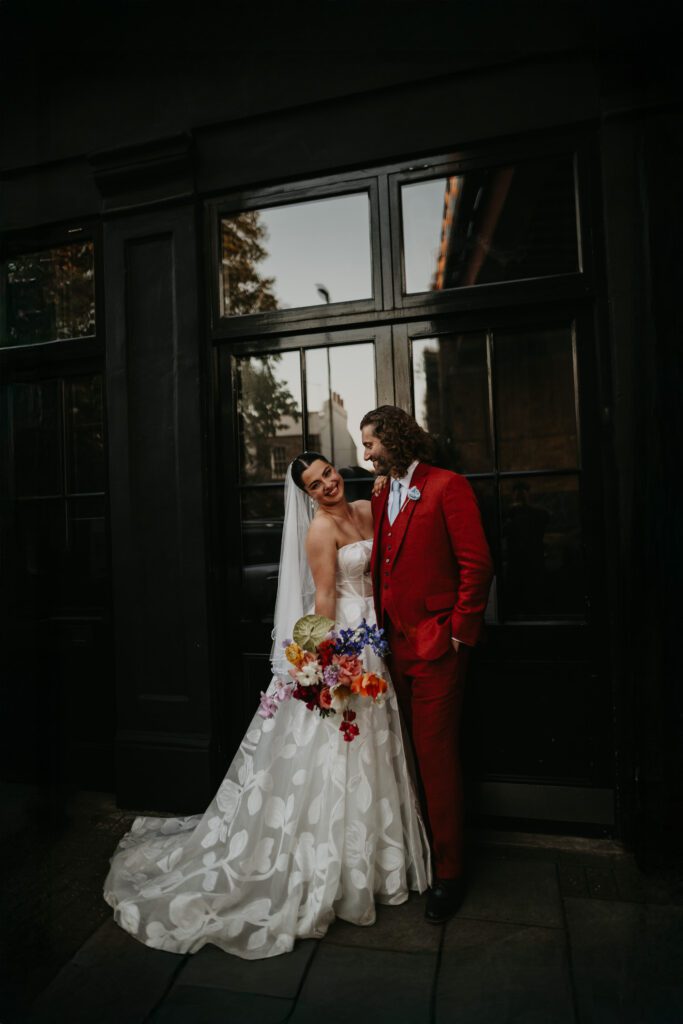 A bride and groom outside the front doors of 100 Barrington on their wedding day.