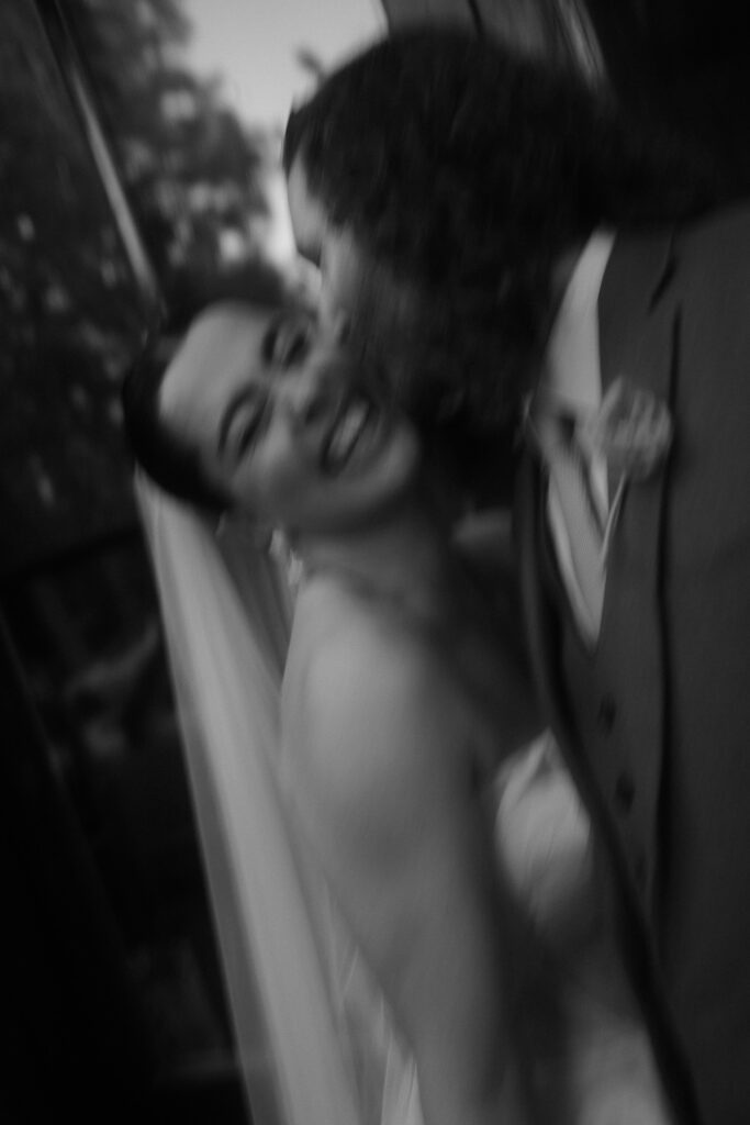 Slow shutter photo of a groom kissing her bride.