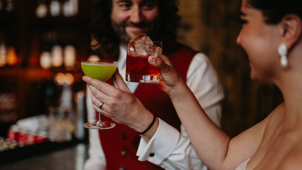 Bride and groom cheers their cocktails at their wedding at 100 Barrington.