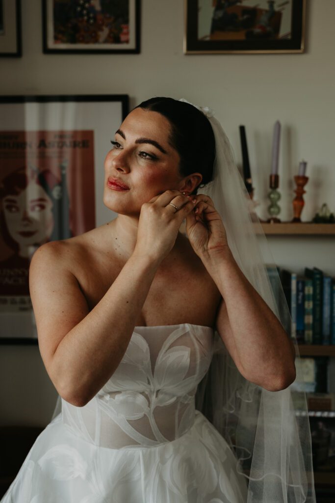 A bride puts on her earrings before her wedding in London.