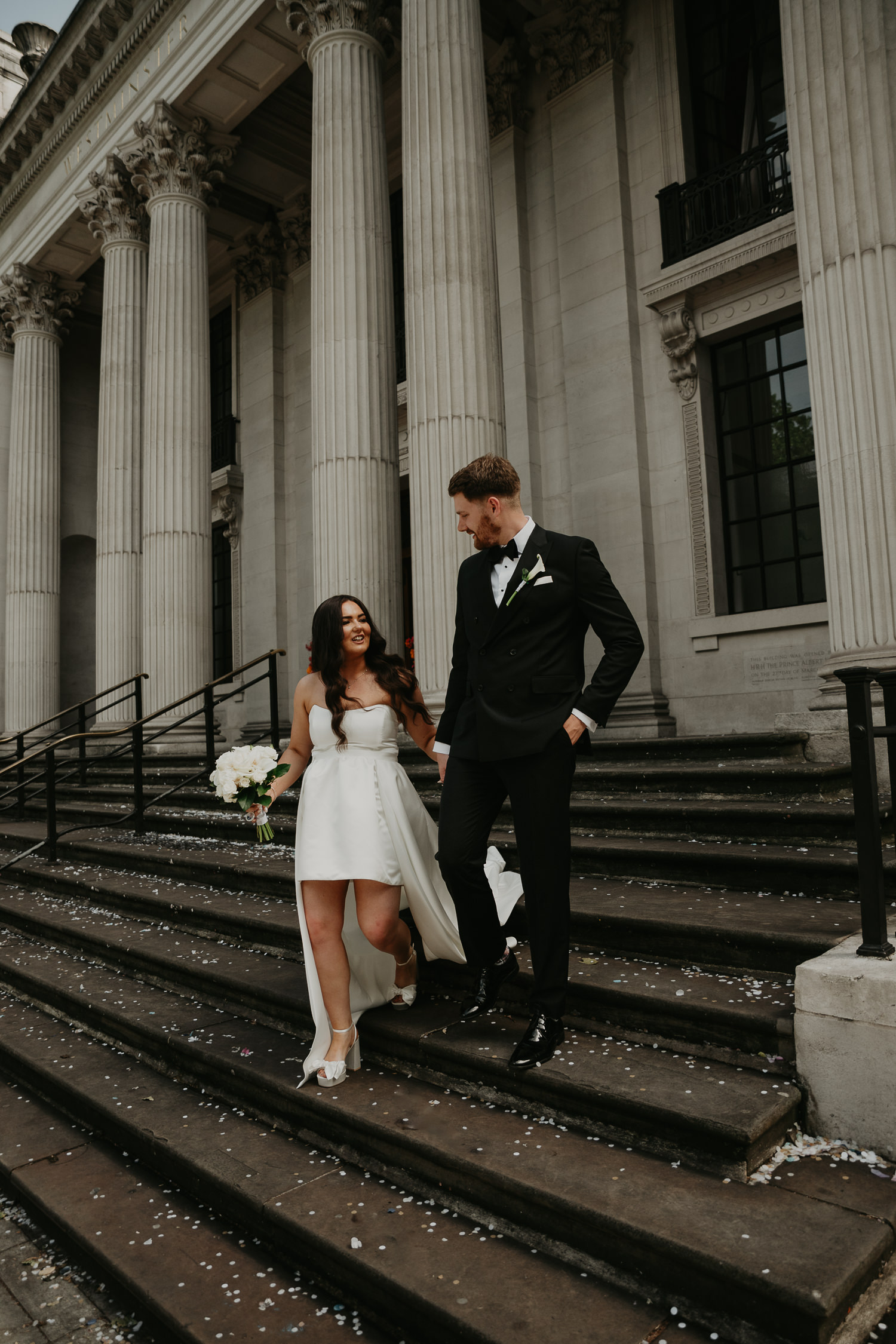Bride and groom walk down the stairs at The Old Marylebone Town Hall.