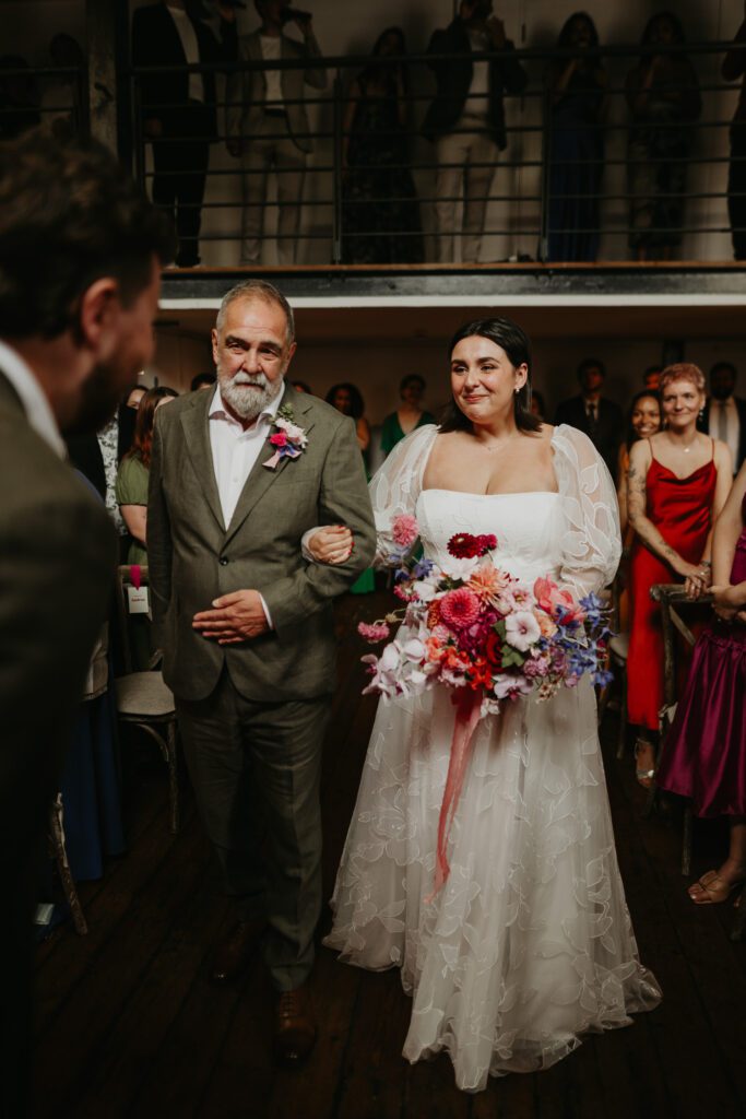 Bride and her father walks down the aisle at Paintworks in Bristol.