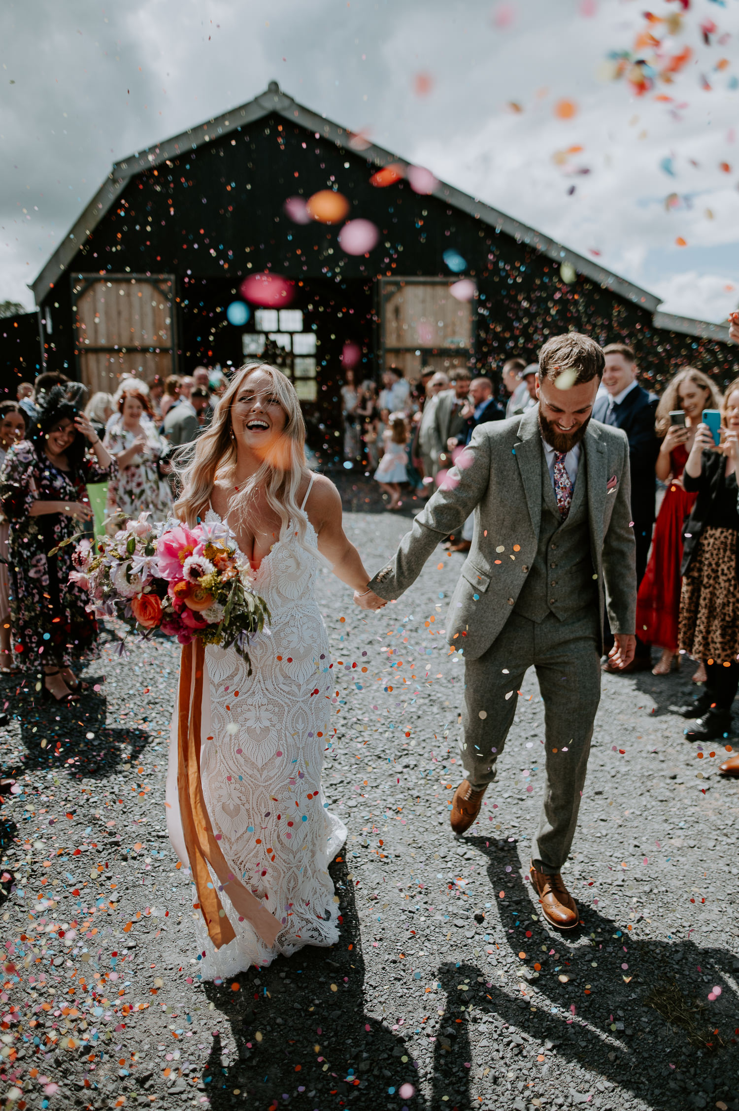 A couple exit the giraffe shed to a shower of colourful confetti.