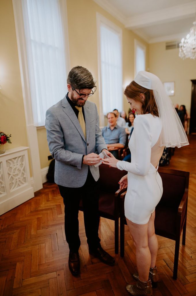 A couple exchange rings at Chelsea Town Hall.