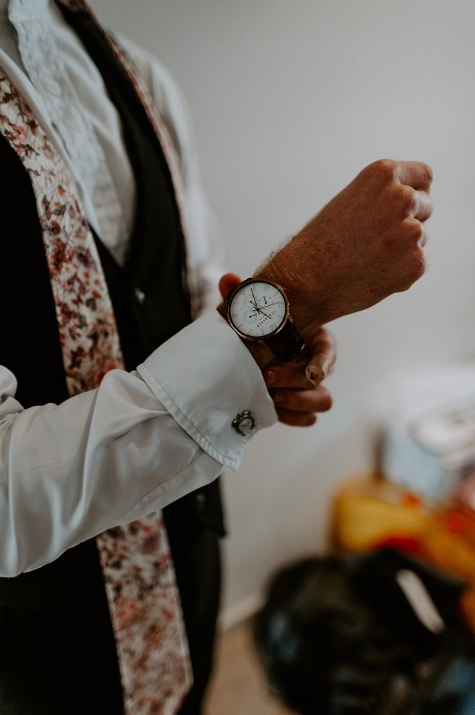 A groom adjusts his watch.