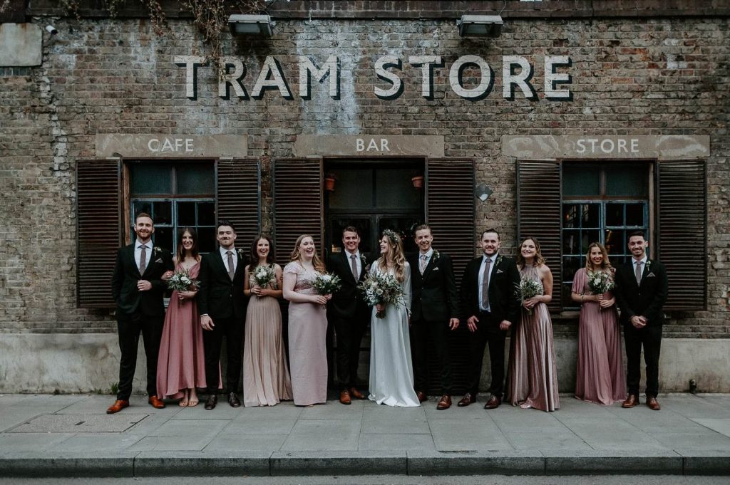 A wedding party group shot outside the Tram Store in Clapton near Clapton Country Club.