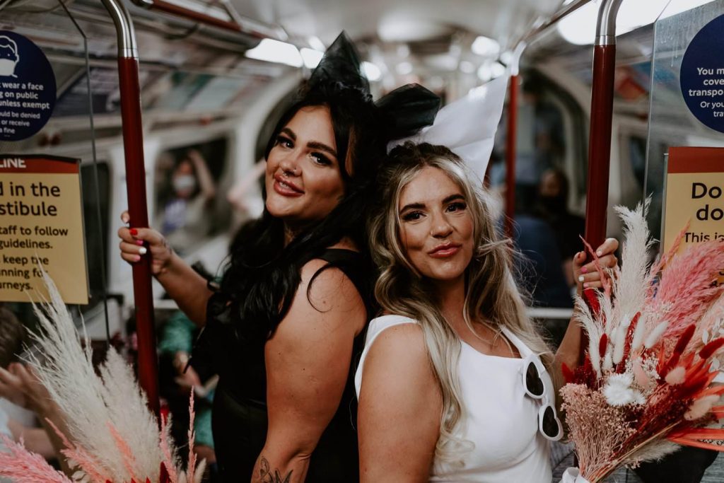 Brides ride the London Underground on their wedding day.