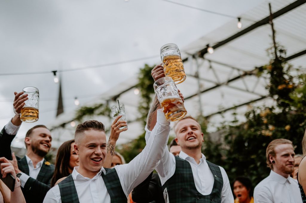 A groomsmen raises his glass during speeches at the shack revolution.