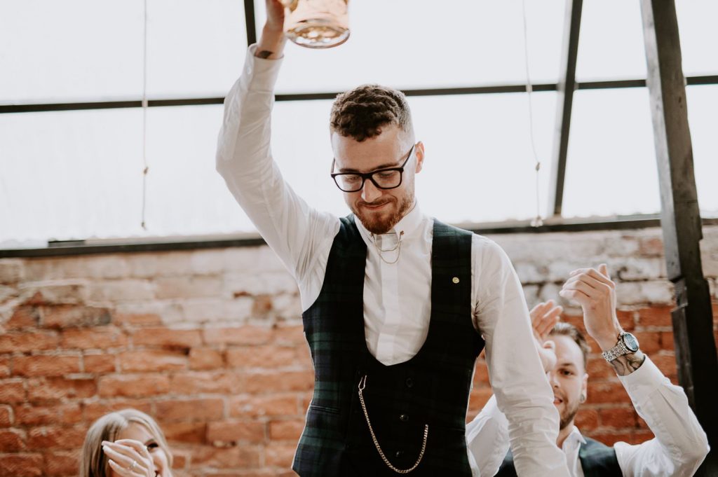 A groom raises her glass during speeches.