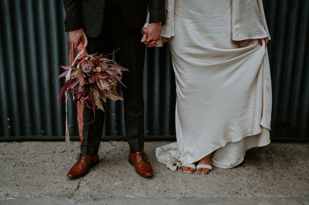 A low detail shot of a bride and grooms feet.