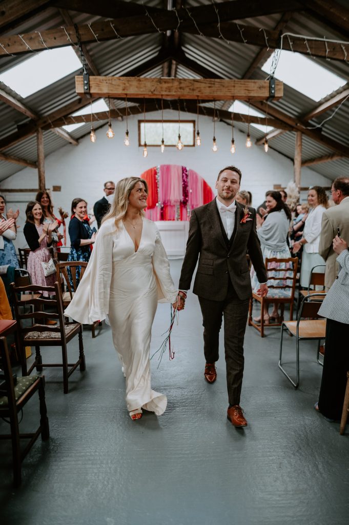 A bride and groom walk out of their wedding ceremony at White Syke Fields in York.