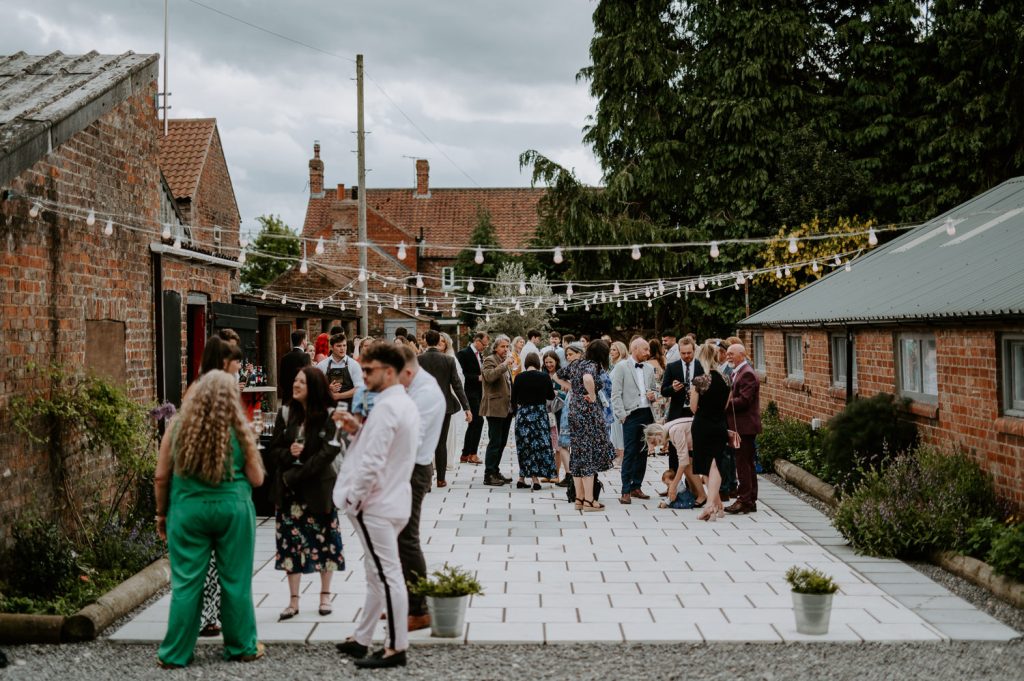 Guests fill the courtyard at White Syke Fields after a ceremony in the barn.