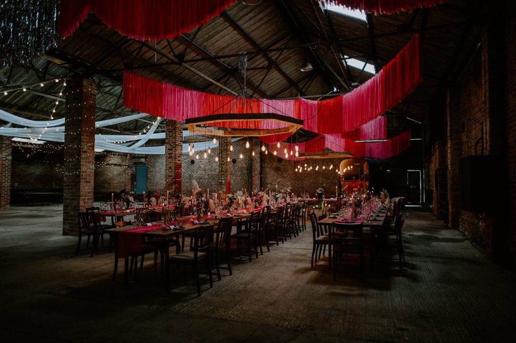 Wide shot of White Sykes Fields barn set up with red and pink streamers across the roof.