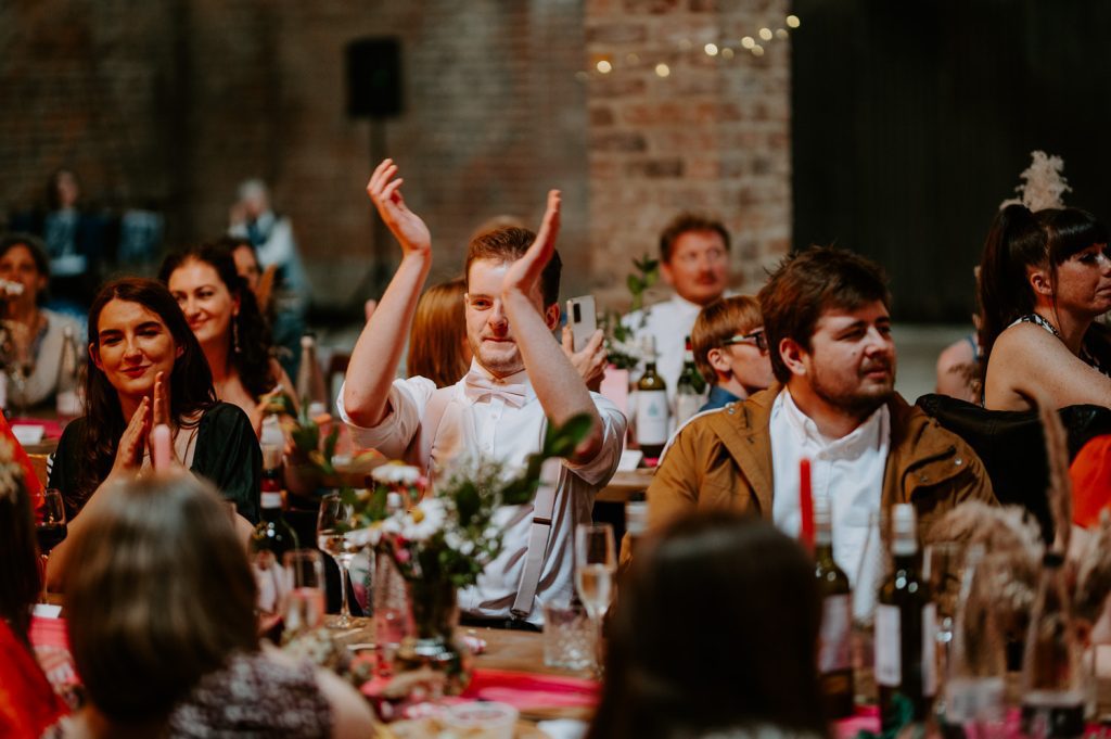 A wedding guest claps during speeches at White Syke Fields.