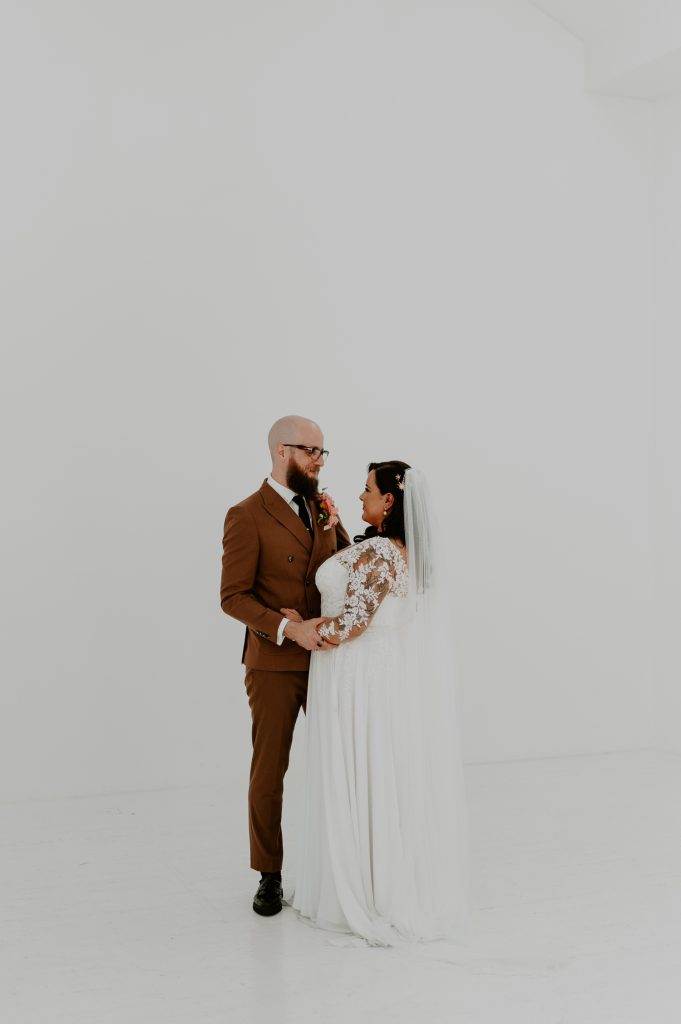 A bride and groom standing in the infinity wall at Five Four Studios.