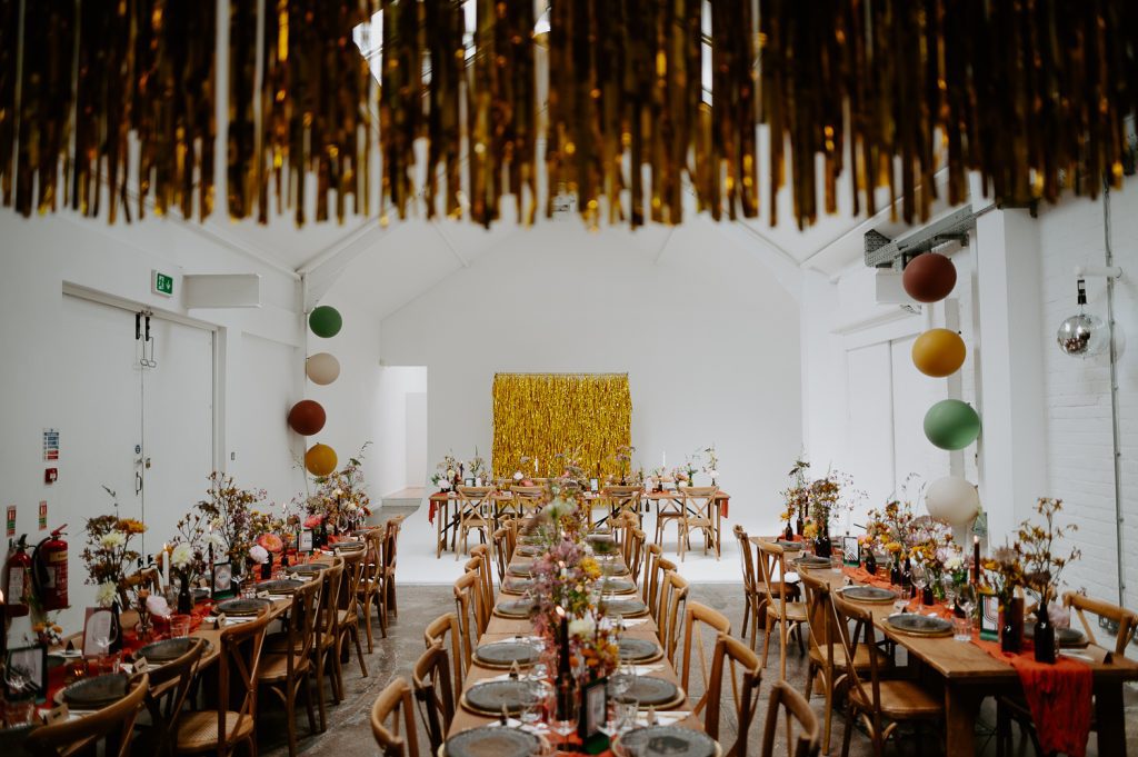 Five Four Studios set out with long trestle tables and streamers for a wedding breakfast.