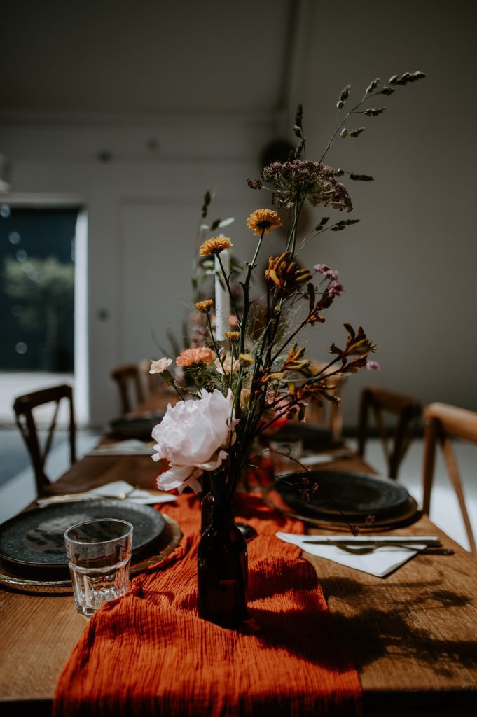 Flowers in a vase set up at a stylishly colourful wedding breakfast at Five Four Studios.