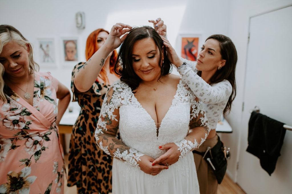 A bride has her hair done before her wedding at Five Four Studios.