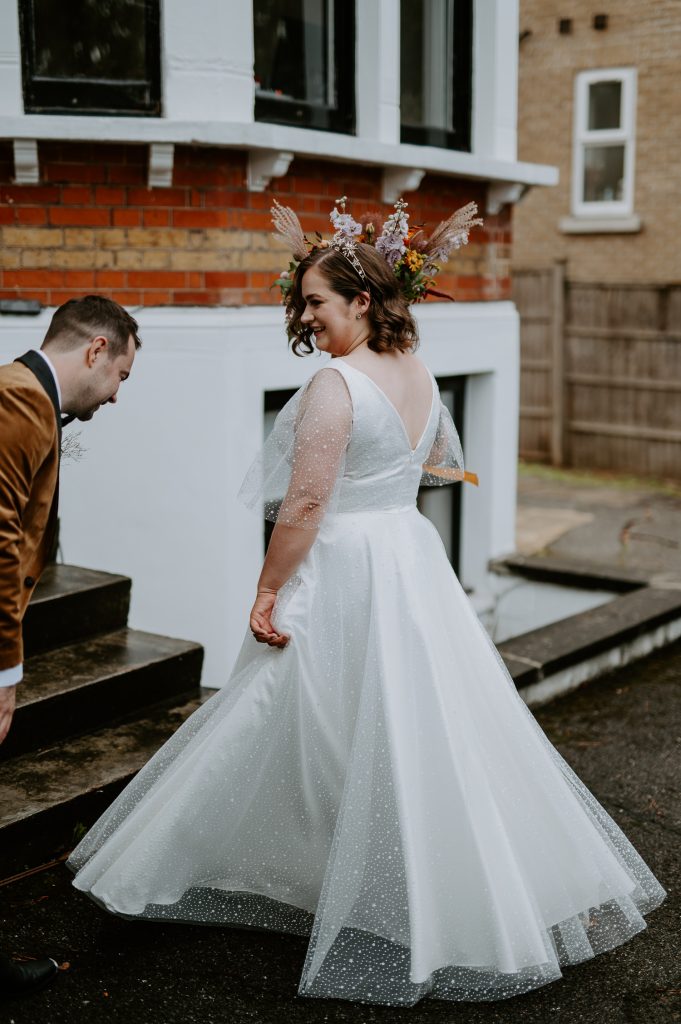 Bride spins her dress to show groom during first look.