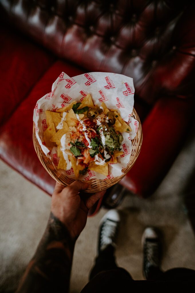 A local Mexican wedding supplier holding a bowl of nachos at an eco-friendly wedding at White Syke Fields in York.