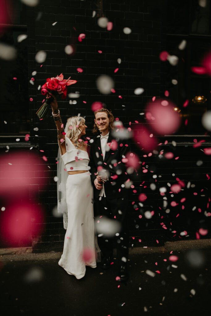A bride and groom let off a biodegradable wedding confetti cannon in the Northern Quarter in Manchester.