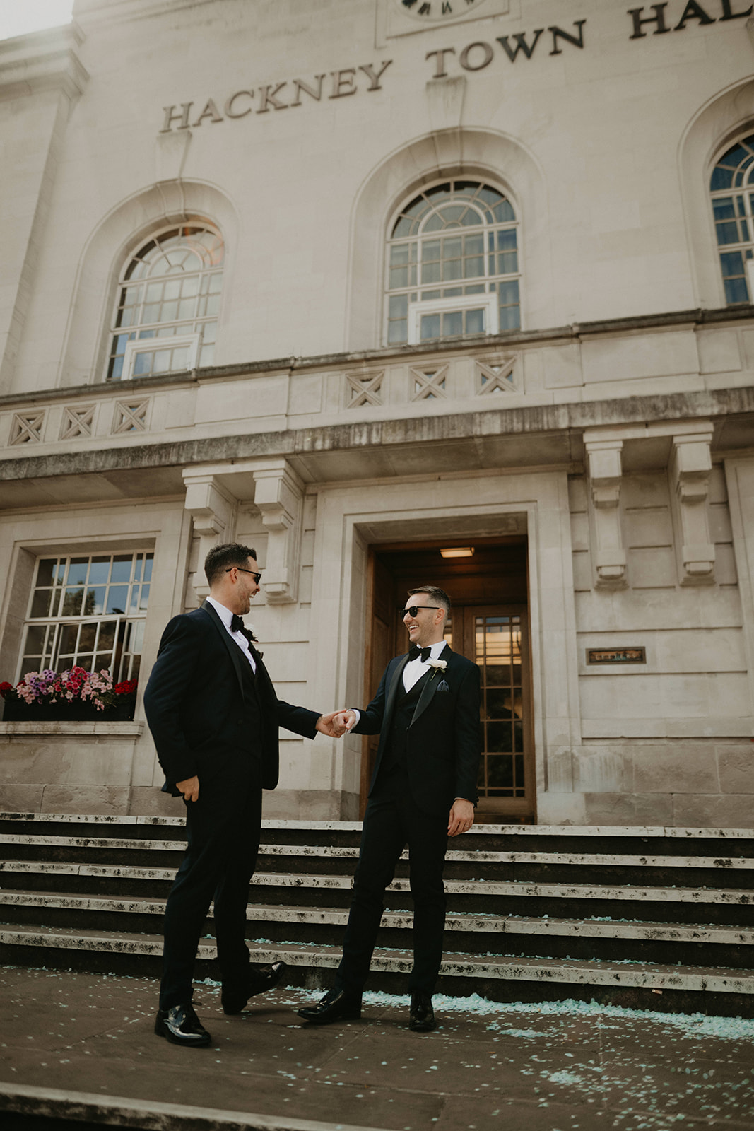 Two grooms on the steps at Hackney Town Hall in London.